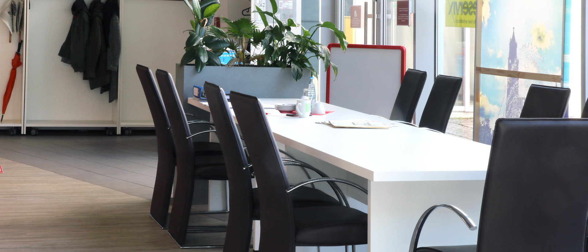 Ein Besprechungstisch mit vielen leeren Stühlen. 