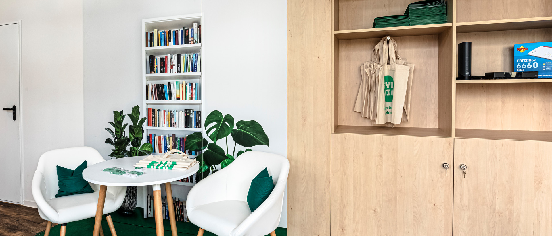 Zu sehen ist die Räumlichkeit der Firma Synvia mit Regalen, zwei Stühlen und einem Tisch. 