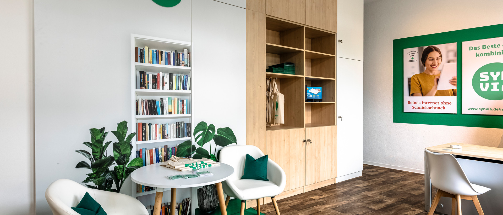 Zu sehen ist die Räumlichkeit der Firma Synvia mit Regalen, zwei Stühlen und einem Tisch. 