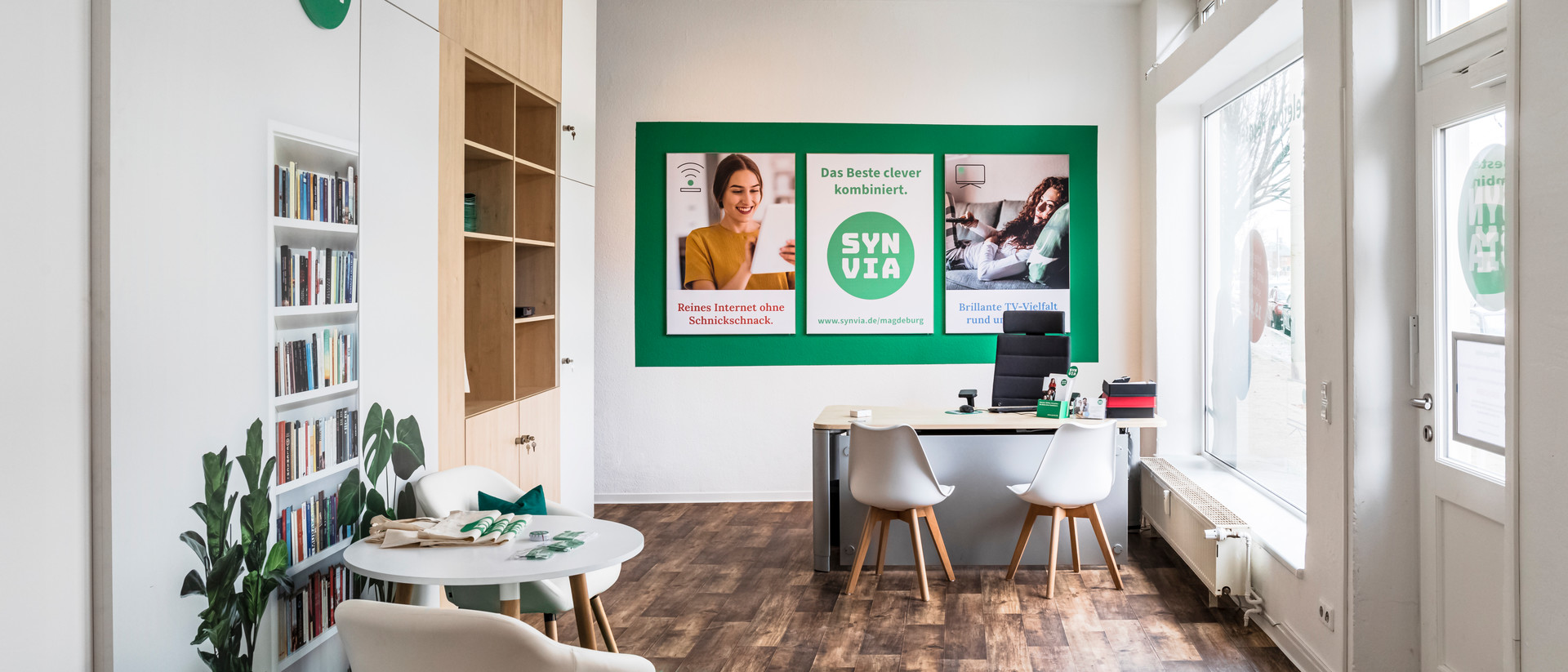 Zu sehen ist die Räumlichkeit der Firma Synvia mit Regalen, Stühlen und Tischen. 